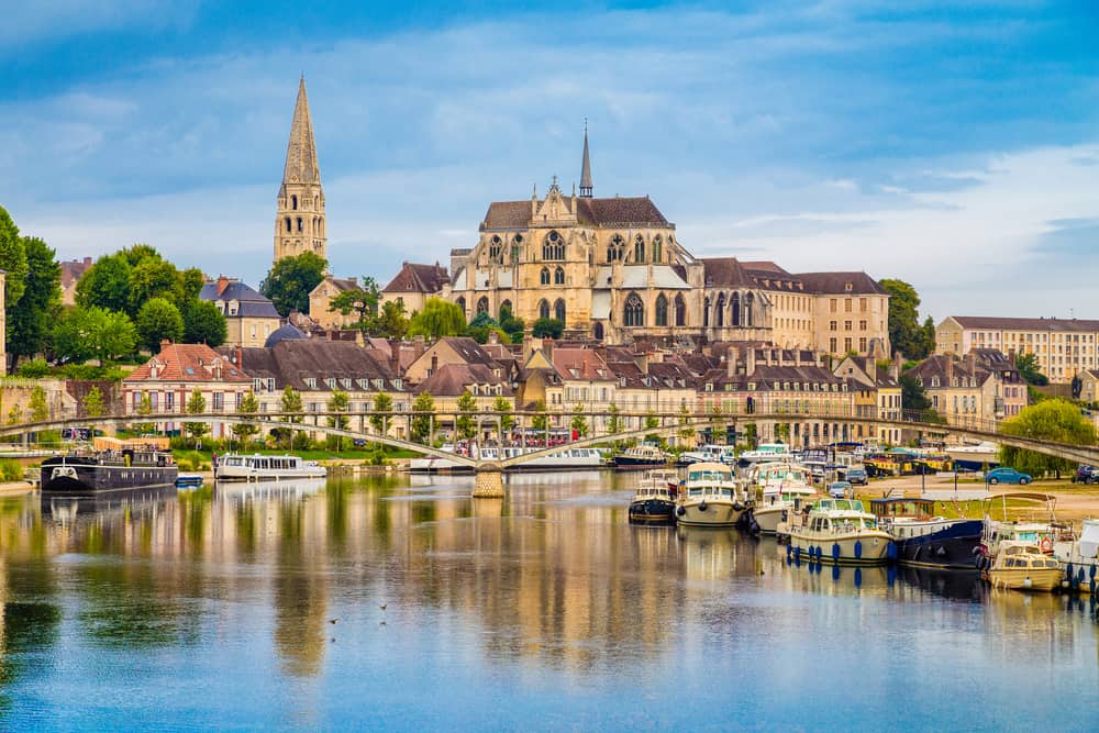 In front the Yonne river with many boats and in the background the majestic city of Auxerre in the Cóte d’Or in Burgundy, France.
