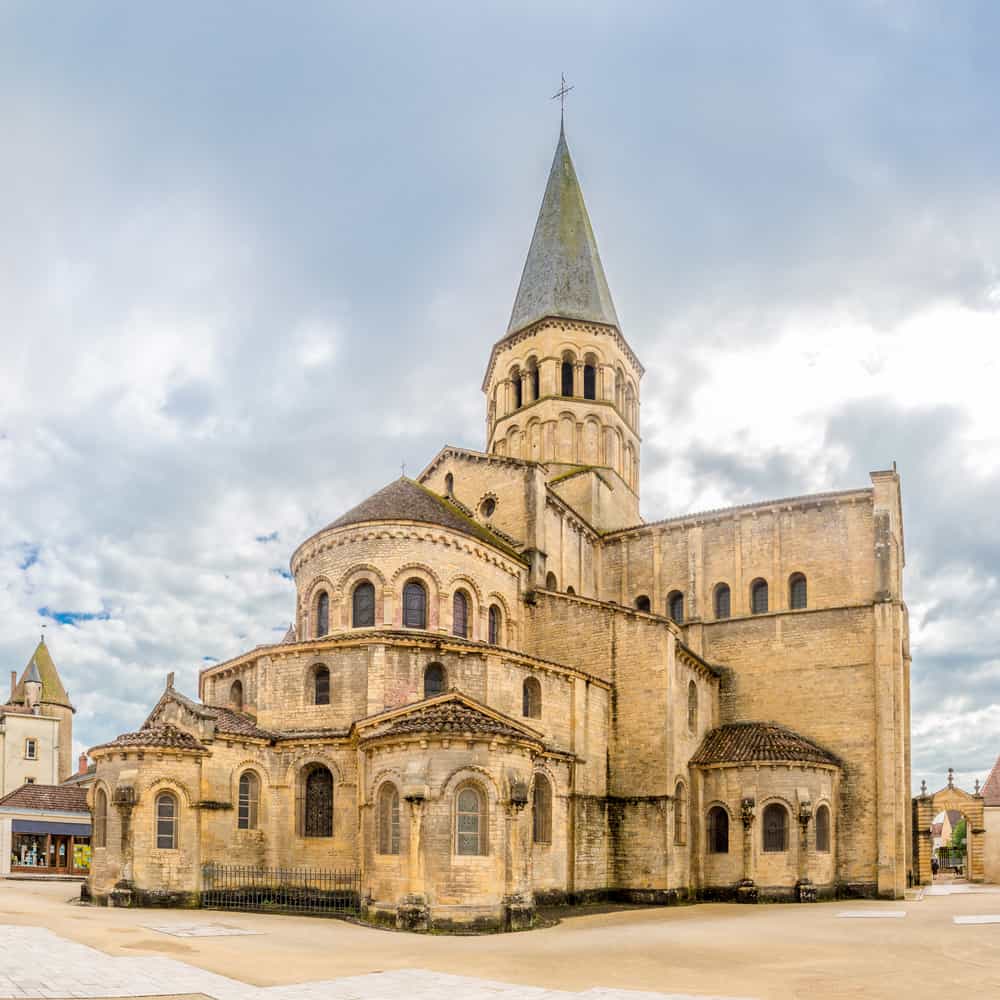 Old church on a square with white skies in the back.