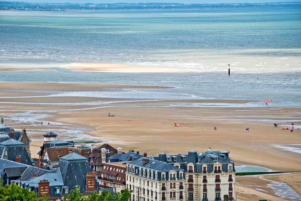 Beautiful wide beach of Houlgate in Normandy, France. The quite ocean in the back and part of the town in front.