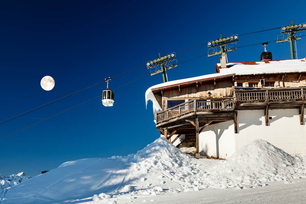 Cable lift station in Megeve in the French Alps. Blue skies and full moon in the background.