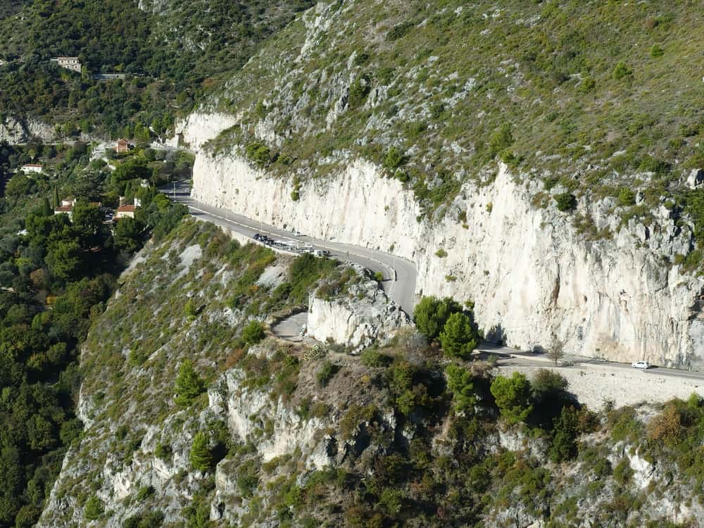 The coastal highway Grance Corniche in France running alongside a mountain.