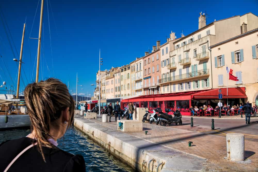 A wowan overlooking the harbor promenade of Saint-Tropez in France.