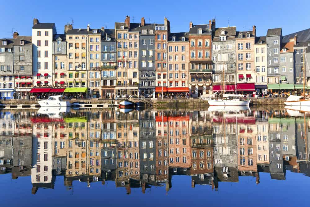 Houses in the Honfleur harbour in Côte Fleurie reflecting in the water.