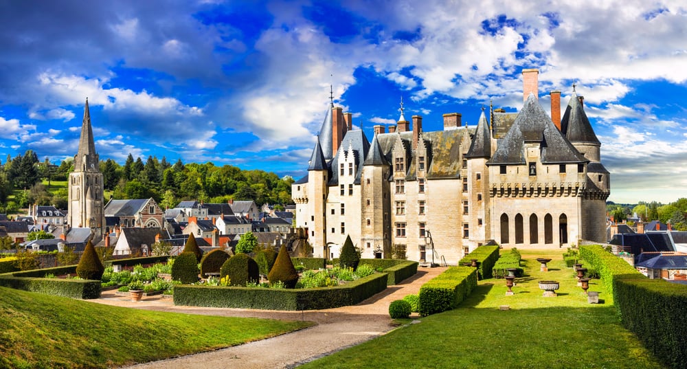 Chateau of Langeais in Loire Valley, France. Beautiful garden in front and the town of Langeais surrounding the castle.