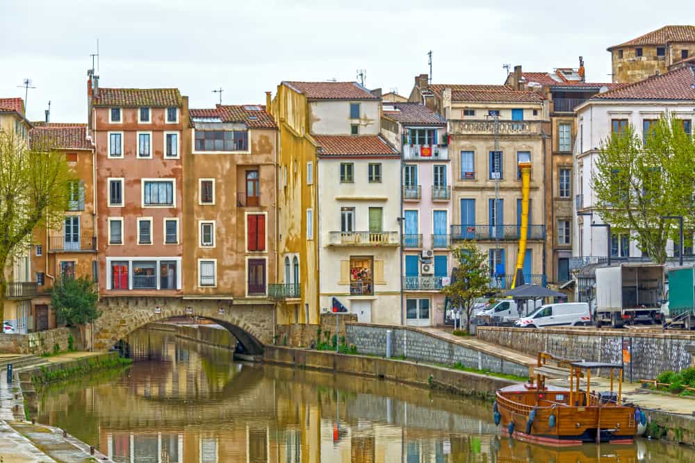 Narbonne in France with old picturesque houses and a canal running through the city.