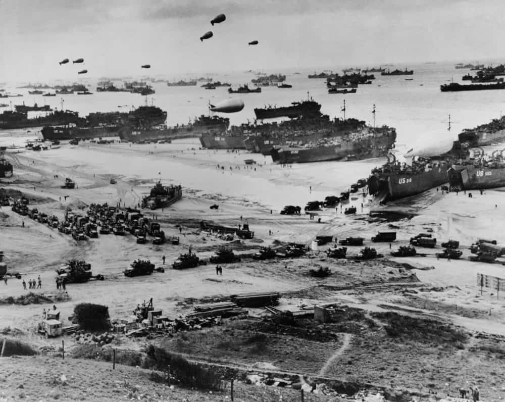 Omaha Beach in Normandy, France after the D-Day invasion. Hot air balloons, war ships, and military vehicles.