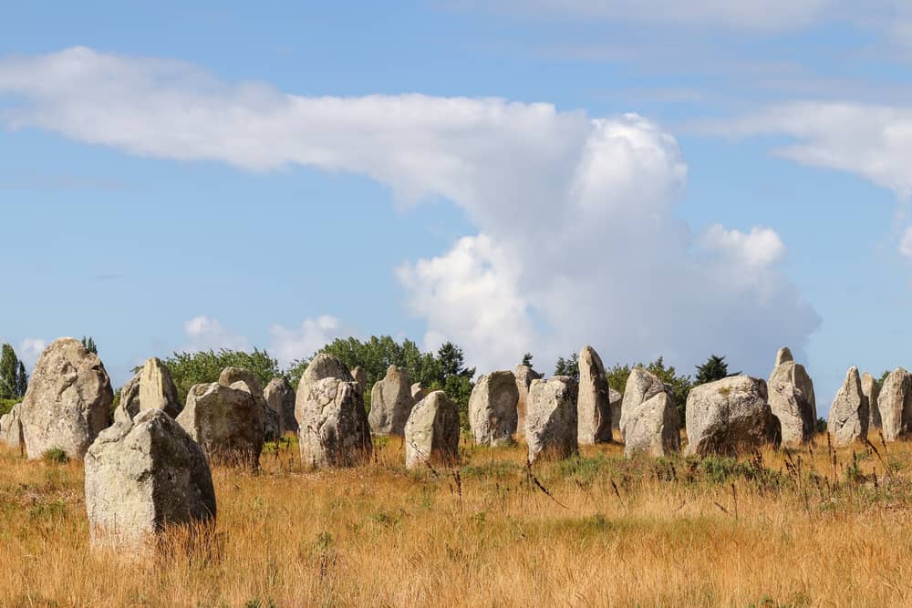 Stone aligments on a field in Carnac on a day with a clear blue sky.