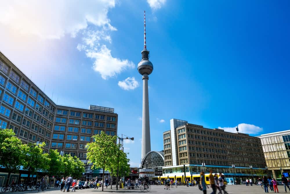 Panoramic view of Alexanderplatz in Berlin with tall building and the Berlin TV Tower in the background.