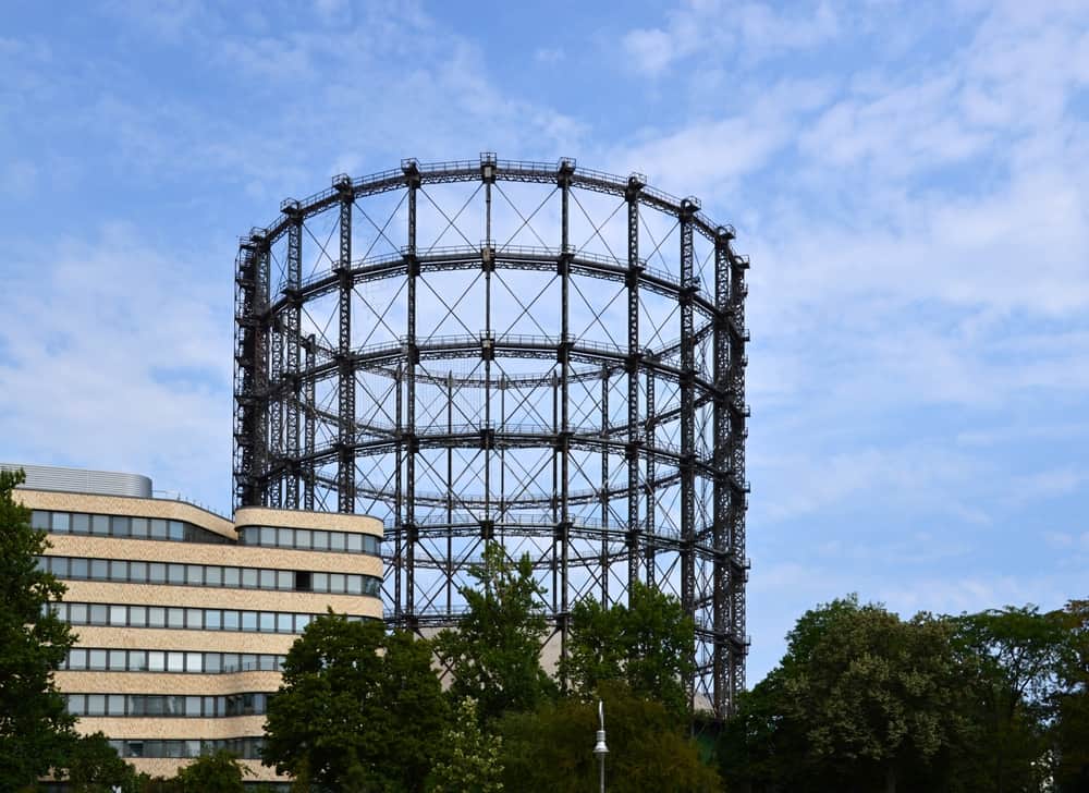 Outside view of Gasometer Schöneberg with trees and buildings in front.