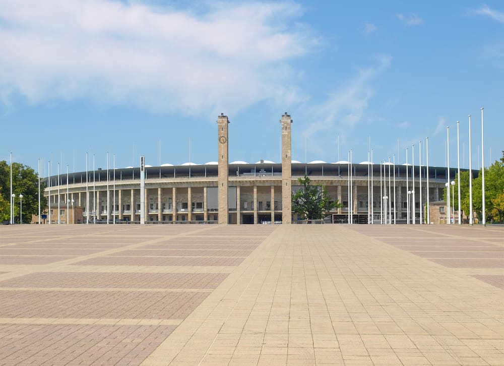 Outside view of the Olympic Stadium in Berlin with its two tall pillars in front.