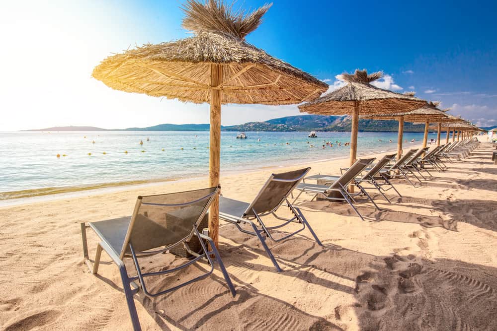 San Ciprianu beach near Porto-Vecchio in Corsica, France. Nice clean sand, beach chairs, umbrellas, and blue ocean.