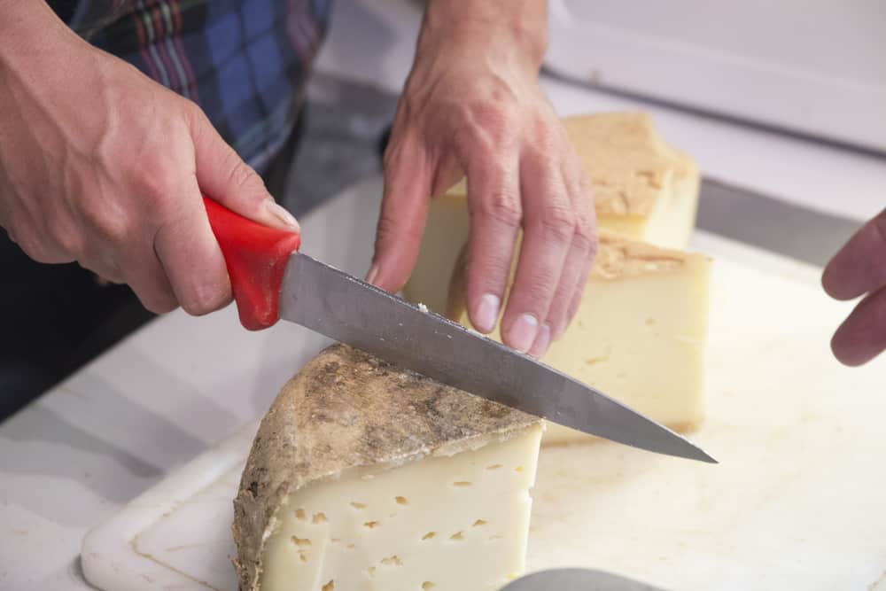 Main cutting a local cheese from Valle de Roncal in Spain.