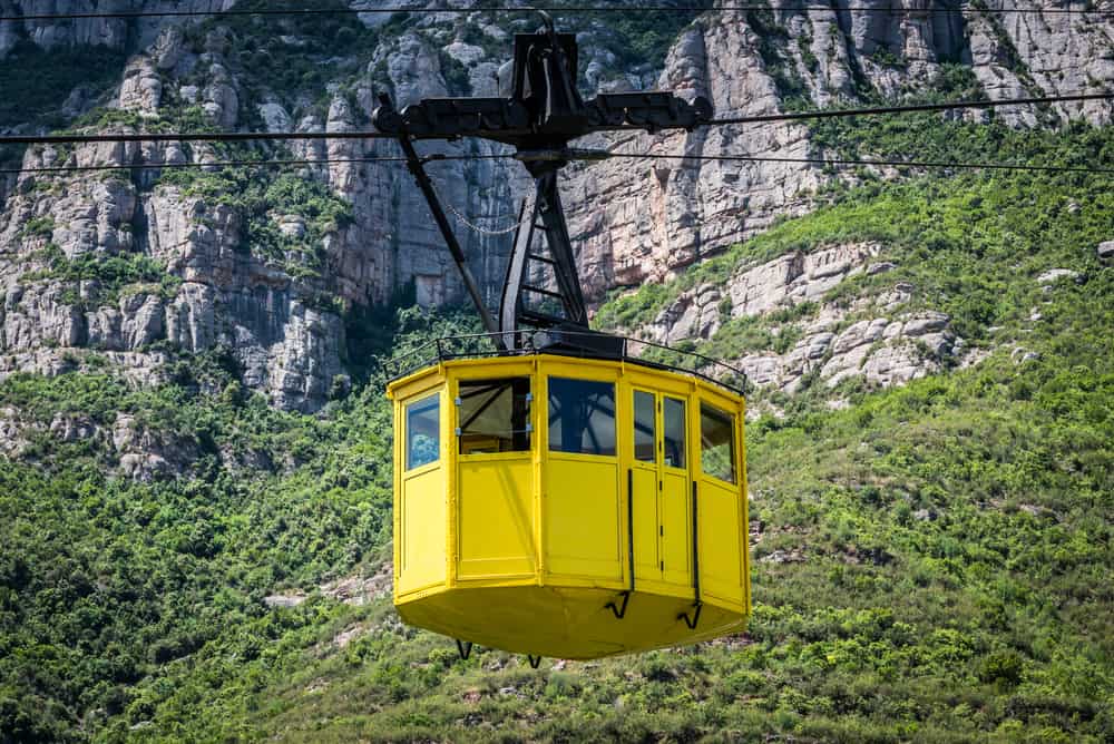 A yellow cable car taking visitors to Santa Maria de Montserrat Abbey in Spain - near Barcelona.